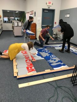 Thompson, Smith, Claire Todd (senior) and Charlie Moore (junior) putting together the canvas